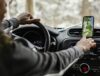 Um motorista dentro do carro com o aplicativo de mapas aberto.