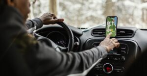 Um motorista dentro do carro com o aplicativo de mapas aberto.