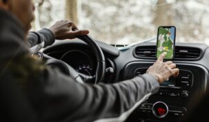 Um motorista dentro do carro com o aplicativo de mapas aberto.